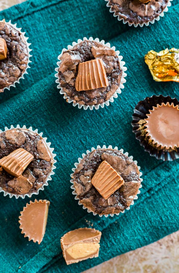 An overheat image of Peanut Butter Cup Brownie Bites with peanut butter cups on a green cloth.