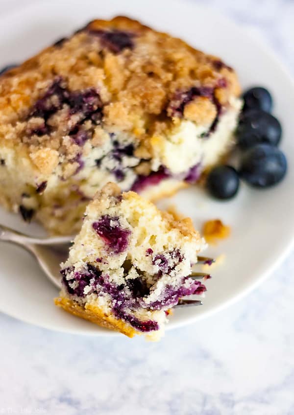 A plate of Blueberry Buckle with a bite of it on a fork.
