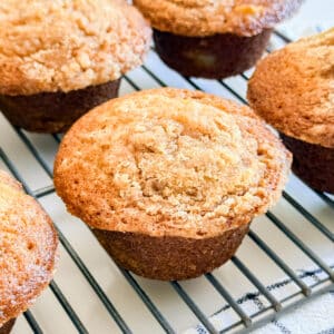 An apple streusel muffin on a cooling rack.