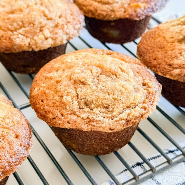 An apple streusel muffin on a cooling rack.