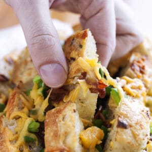 This cheesy Jalapeno Popper Pull Apart Bread is an easy recipe for game day! A loaf of bread stuffed with jalapenos, cheese and bacon; it's super quick to throw together and is sure to be a hit at your next Superbowl Party!