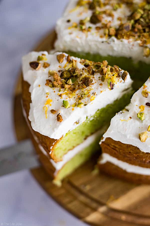This Lemon Pistachio Cake is the best easy recipe when you need a quick cake to wow your guests. This is actually a hack for a box cake mix made with pudding and topped with light and fluffy whipped cream. The result is a super moist and pretty layered cake that is so good your guests will never guess that it's only halfway homemade!