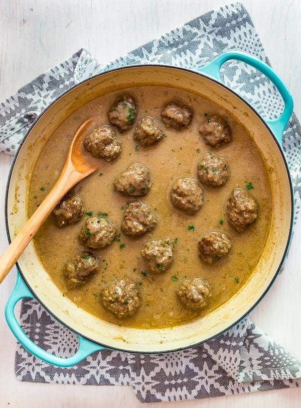 An overhead image of a pan full of Classic Swedish Meatballs with a spoon in it.