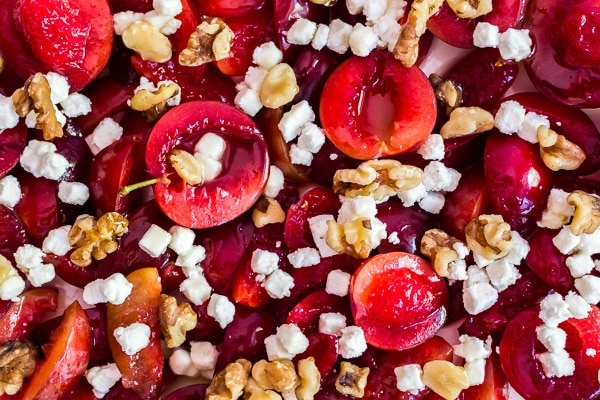An upclose, overhead shot of plums with goat cheese and walnuts.