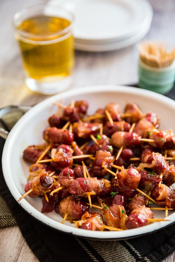 A plate of Bacon Brown Sugar Cocktail Wienies with a beer in the background.