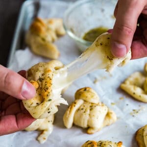 A square image of a Cheesy Garlic Knot being stretched.