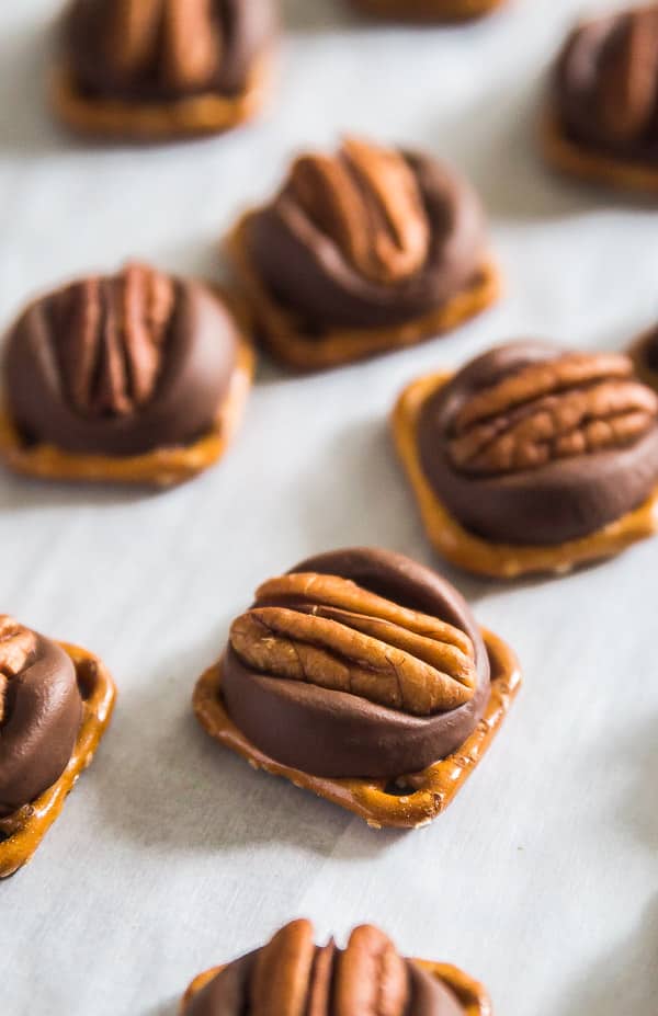 Chocolate Caramel Pretzel Turtles on a pan lined with parchment paper.
