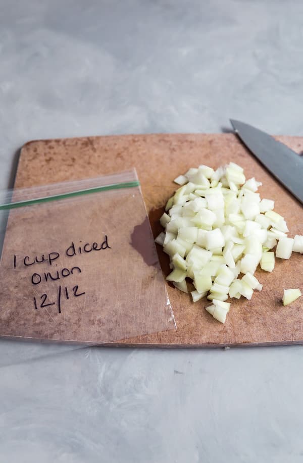 An empty bag and chopped onions on a cutting board.