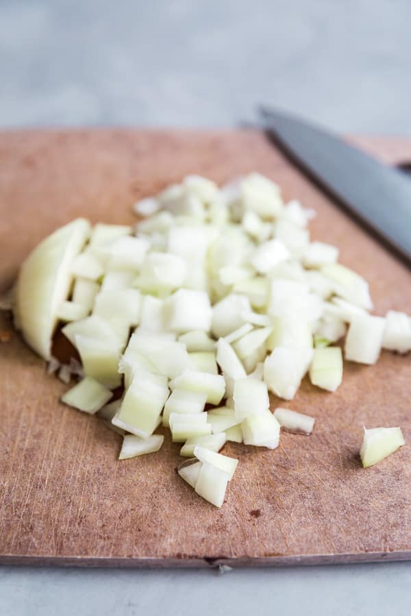 Chopped onions on a cutting board.