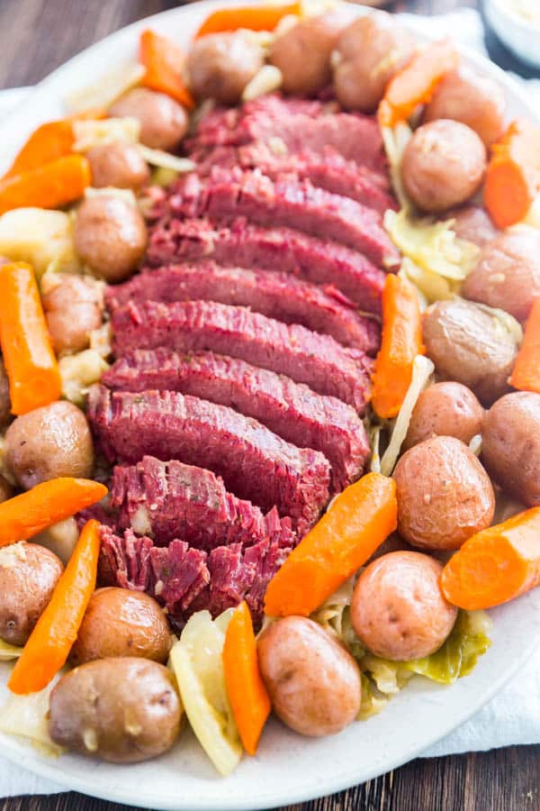 A large platter of corned beef and cabbage with potatoes and chunks of carrots.
