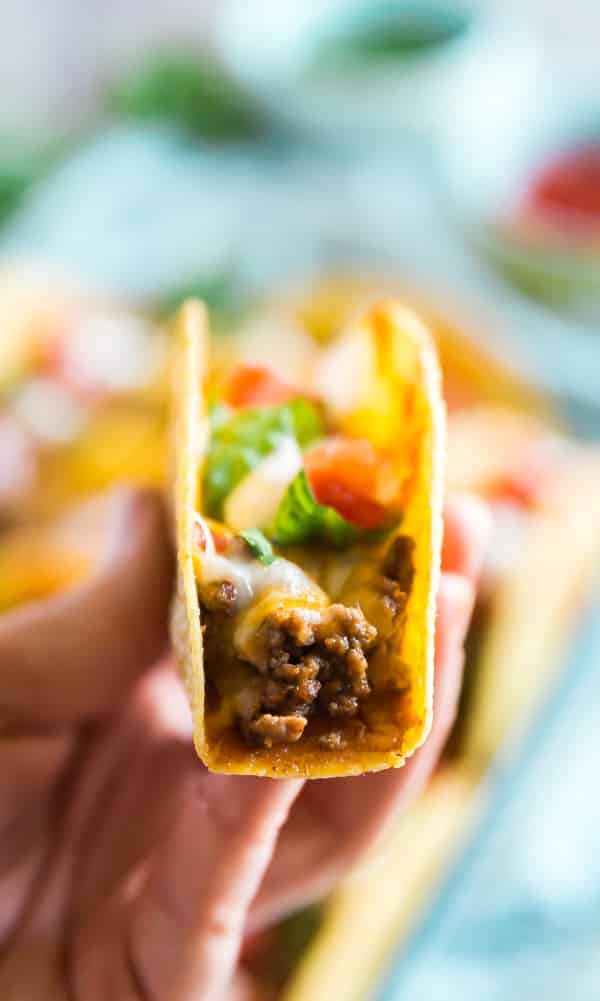 A hand holding up a Ground Beef Oven Baked Taco.