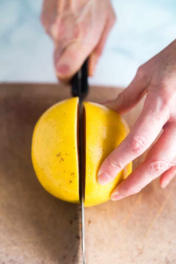 A knife cutting a grapefruit in half..