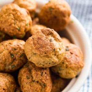 Greek Baked Turkey Meatballs are a tasty appetizer or an excellent main dish. They're insanely easy to whip up and a healthy option as well! Ground turkey, lemon juice and greek spices make a delicious and flavorful meatball that tastes awesome with tzatziki sauce!
