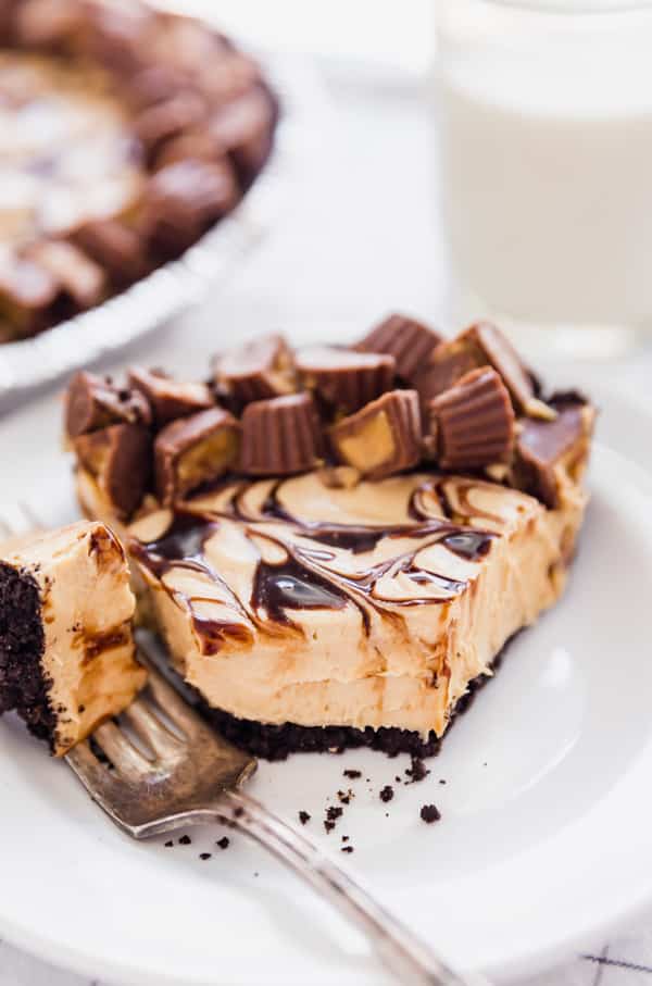 Rich and Creamy Peanut Butter Pie is the dessert that dreams are made of and best of all, it's no bake! Oreo cookie crust, creamy peanut butter filling, swirls of chocolate sauce and plenty of mini peanut butter cups. You will make this again and again!