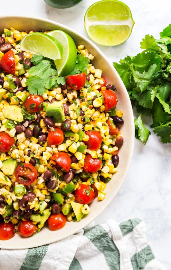 Cajun Black Bean and Corn Salad is an excellent no-mayo salad option to bring to a picnic and a great meal prep option for a light lunch you can eat all week. Made with fresh grilled corn, black beans, tomatoes, peppers, green onion and avocado with a lightly spicy cajun lime dressing, this is a new family favorite recipe!