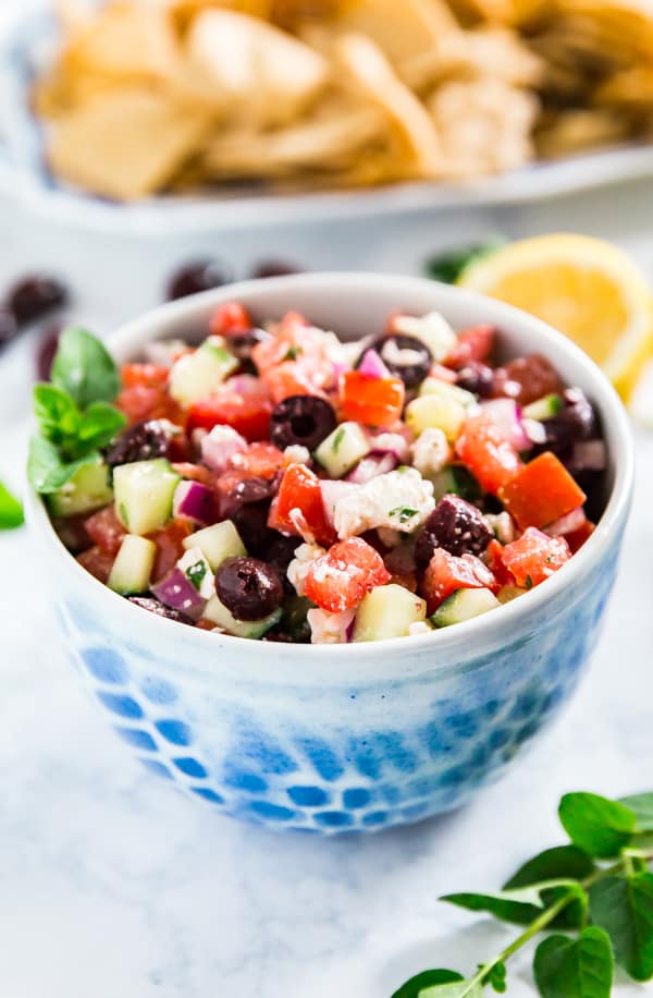 Greek Salsa is a light, healthy and fresh take on a traditional salsa- it's super easy to make with tomatoes, cucumber, olives, oregano, lemon juice, onions and feta cheese. This is so delicious, you won't be able to stop eating it!