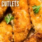 A close up overhead image of chicken cutlets on a plate with brown parchment and a few sprigs of fresh parsley.