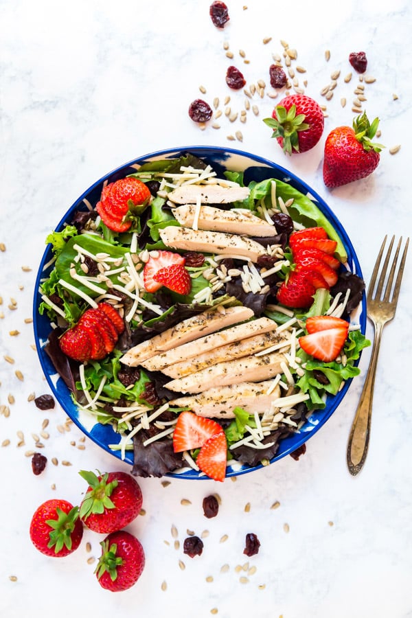 Summer Bounty Strawberry Salad with Fresh Strawberry Vinaigrette is a light and fresh lunch! Made with some unexpected ingredients like greens, strawberries, white cheddar, sunflower seeds and dried cherries this salad is as healthy as it is delicious! 