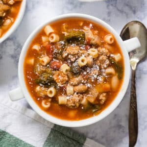 If you're looking for a hearty, delicious soup to warm you up on the coldest nights, this Bean and Sausage Soup is a total winner! Made with 3 different types of beans, Italian sausage and fresh escarole in a tomato broth, this is a seriously easy dinner the whole family will love!