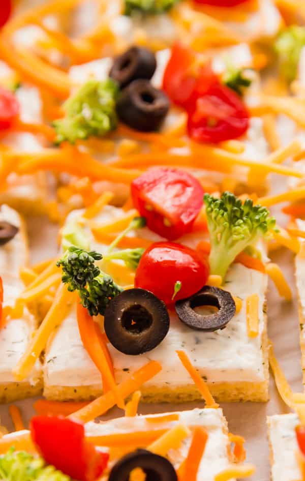A close up image of a piece veggie pizza surrounded by other pieces.