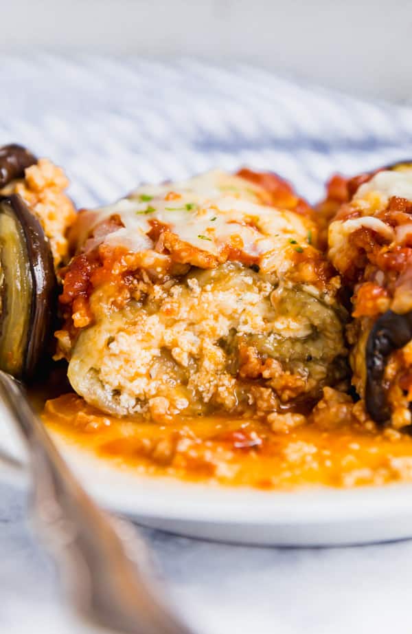 A straight-on image of eggplant rollatini that's been sliced open revealing the cheese inside it.