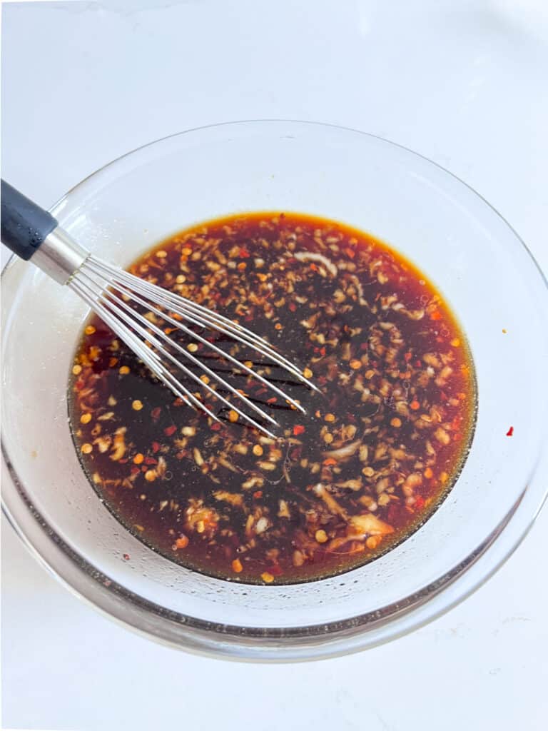 Marinade in a bowl with a whisk in it.