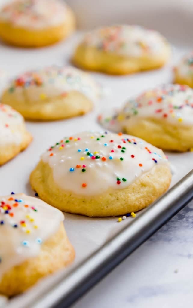 A side angle show of cookies on a lined cookie sheet.