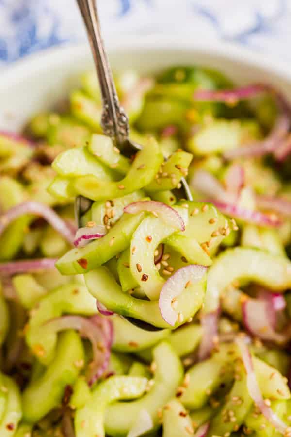 A close up image of a spoon with a scoop of this cucumber salad recipe
