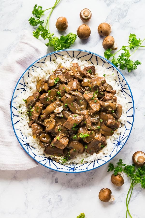 An over head image of a bowl of the beef tips recipe over white rice.