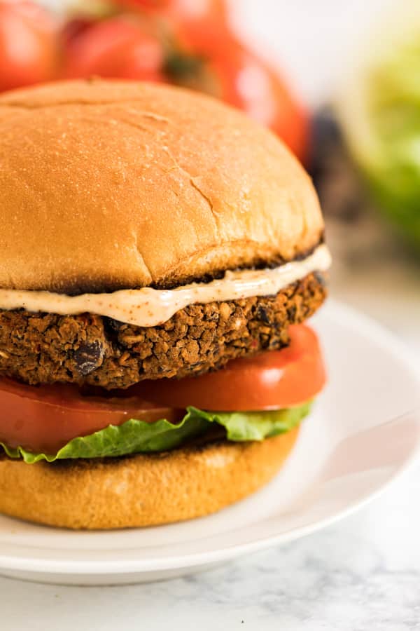 A close up photo of the side of a black bean burger recipe on a bun.