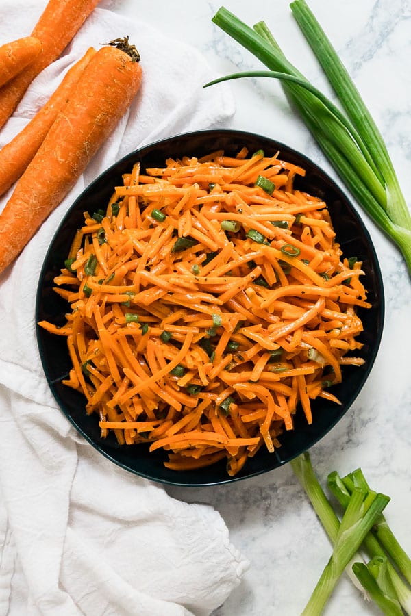 An overhead image of a bowl of shredded carrot salad