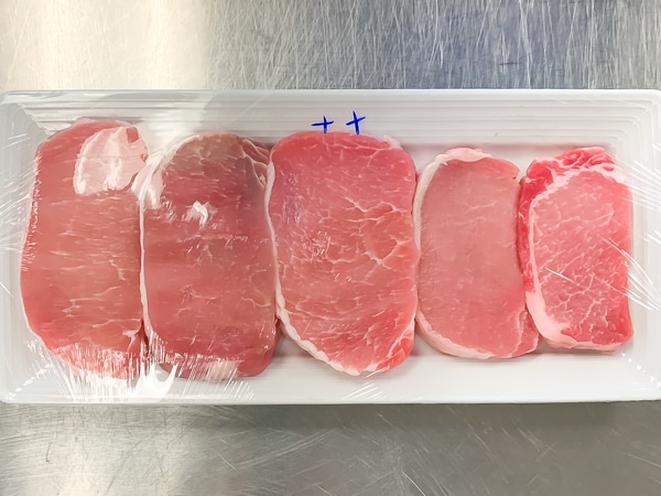 5 pork chops on a plate illustrating the visual differences.between them.