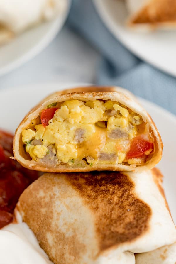 A close up image of the inside of the burrito with eggs and sausage.