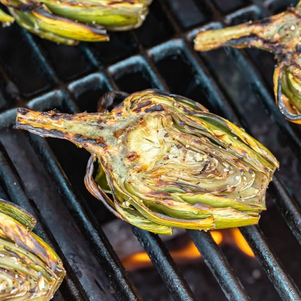 Grilled Artichokes are the perfect summer snack or appetizer! They're extremely easy to make with minimal ingredients and served with a dipping sauce of creamy lemon garlic aioli that you're sure to love!