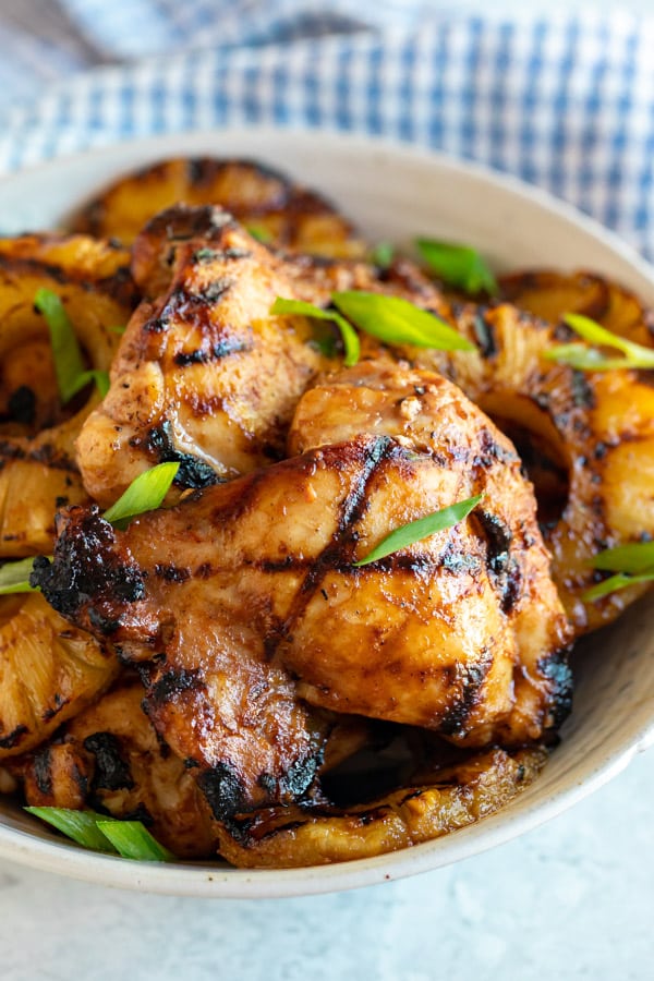 A close up image of bbq chicken thighs in a bowl