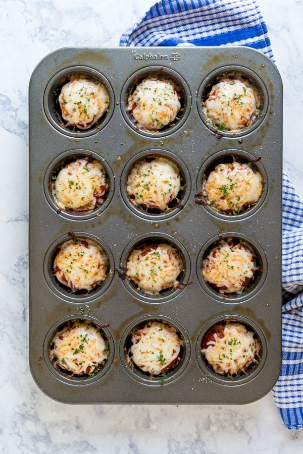 An overhea image of a muffin pan with cooked meat loaf muffins in it.