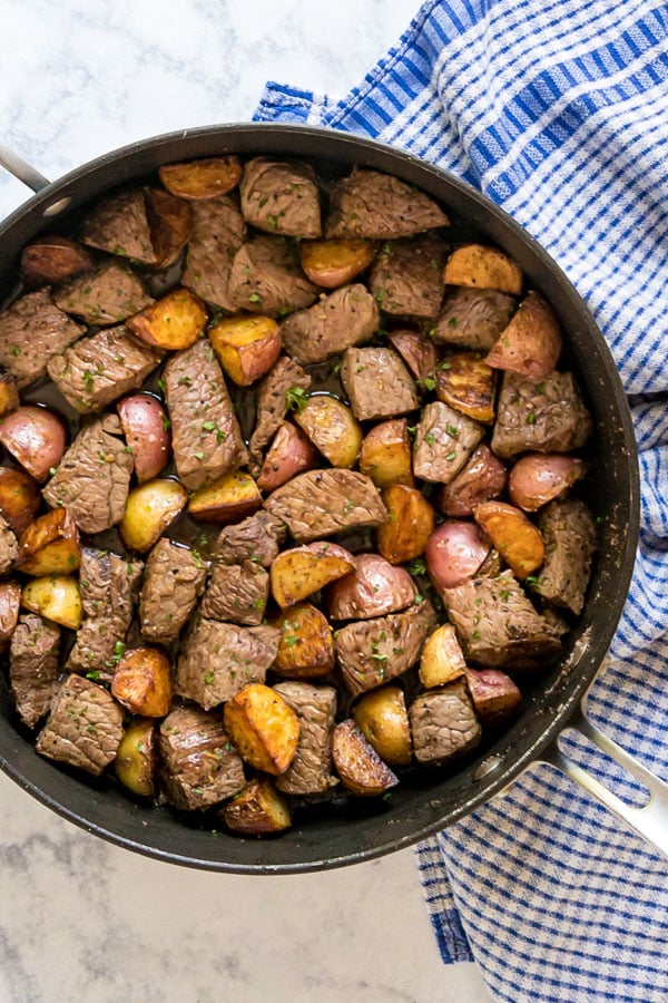 An overhead image of a pan of steak and potato bites.