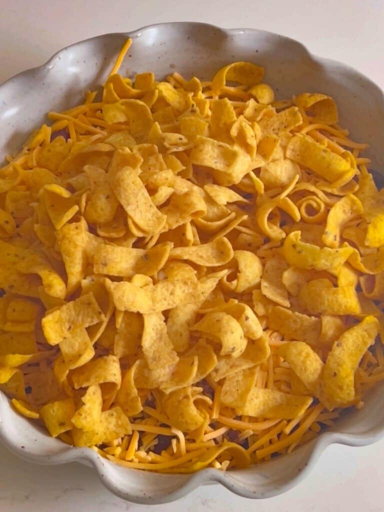 The casserole in a large baking dish with Fritos on top, ready to bake.