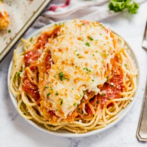 Chicken Parmesan on a bed of spaghetti and red sauce.