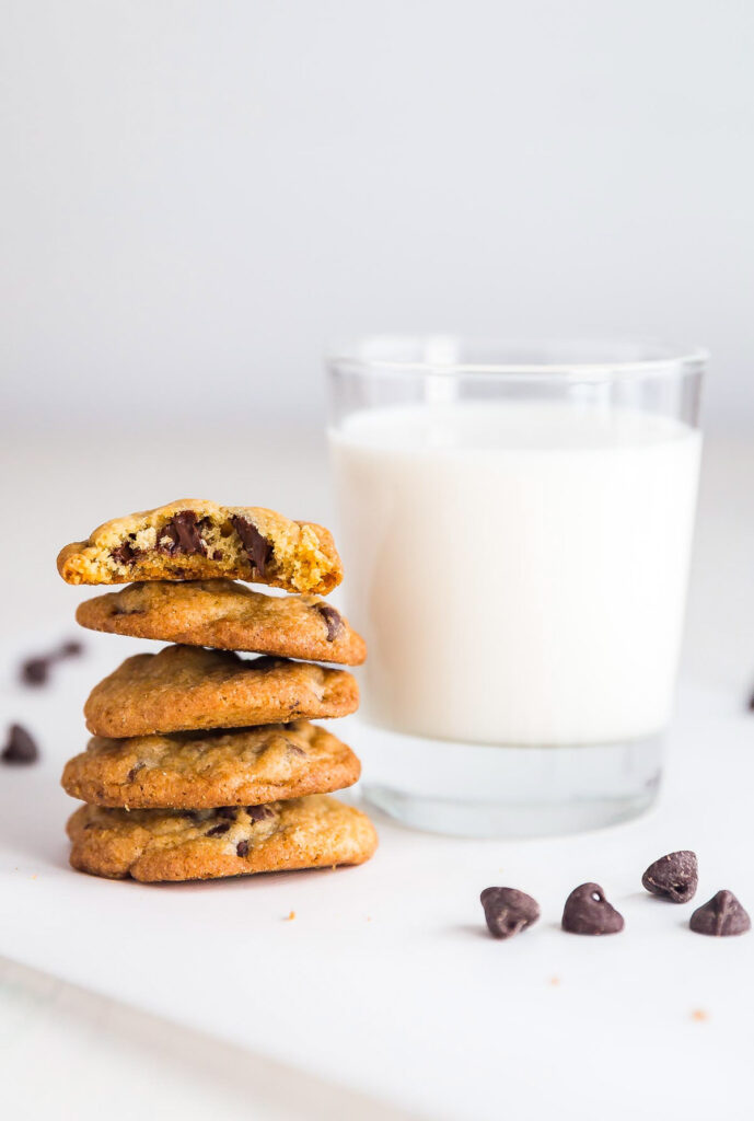 An image of a stack of cookies next to a glass of milk.