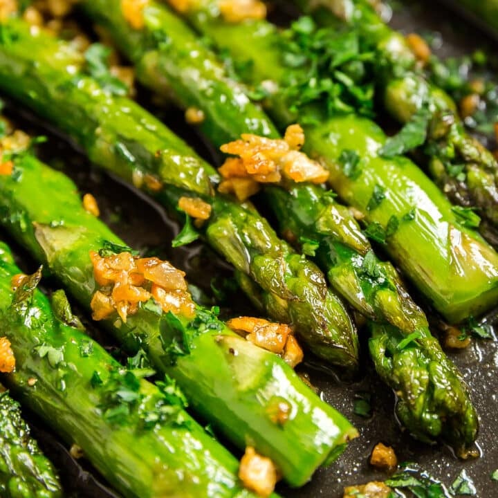 An extreme close up of the ends and tips of skillet asparagus in a pan