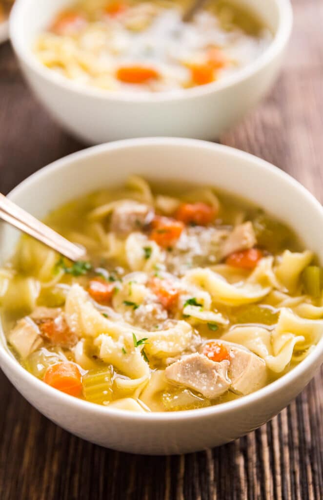 A close up image of a bowl for chicken soup with noodles.