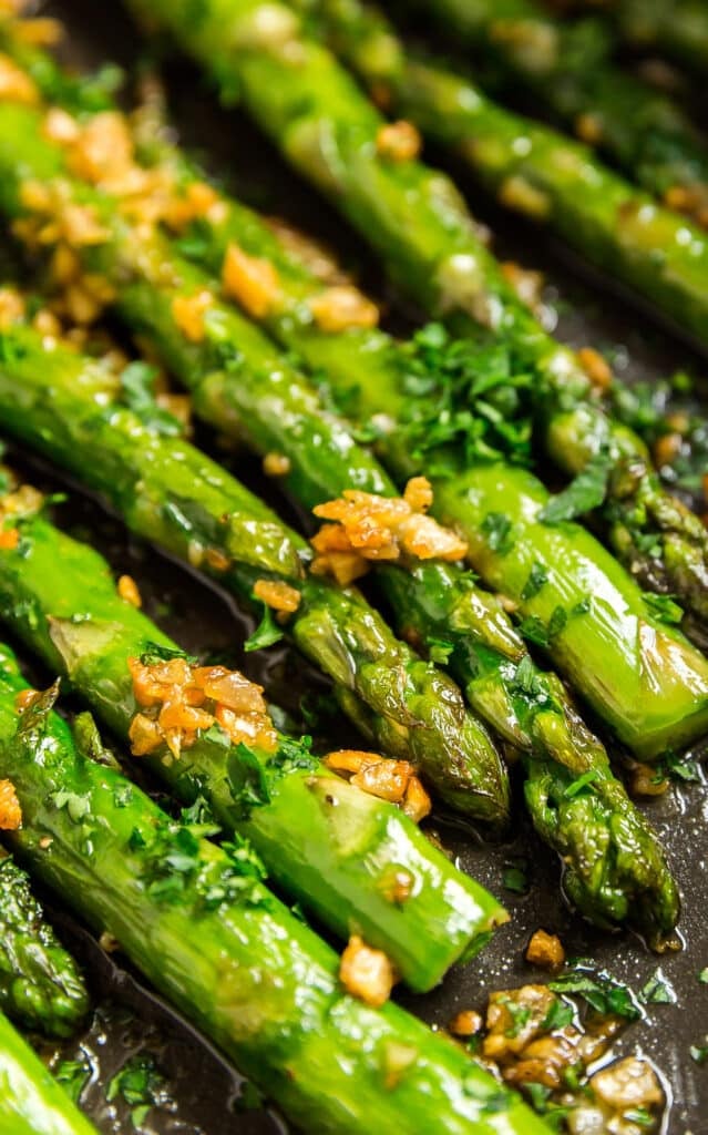An extreme close up of the ends and tips of skillet asparagus in a pan