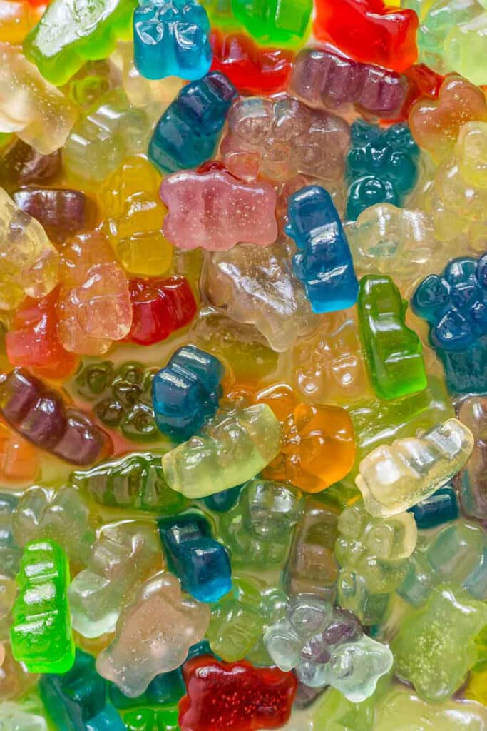 A close up image of gummy bears soaked in vodka.