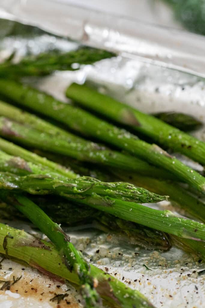 A close up image of the asparagus on a foil lined sheet pan.