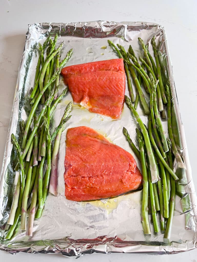 Salmon and asparagus on a foil lined sheet pan.