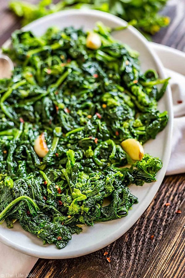 broccoli rabe recipe with garlic on an oval plate with the left side of the plate cut off