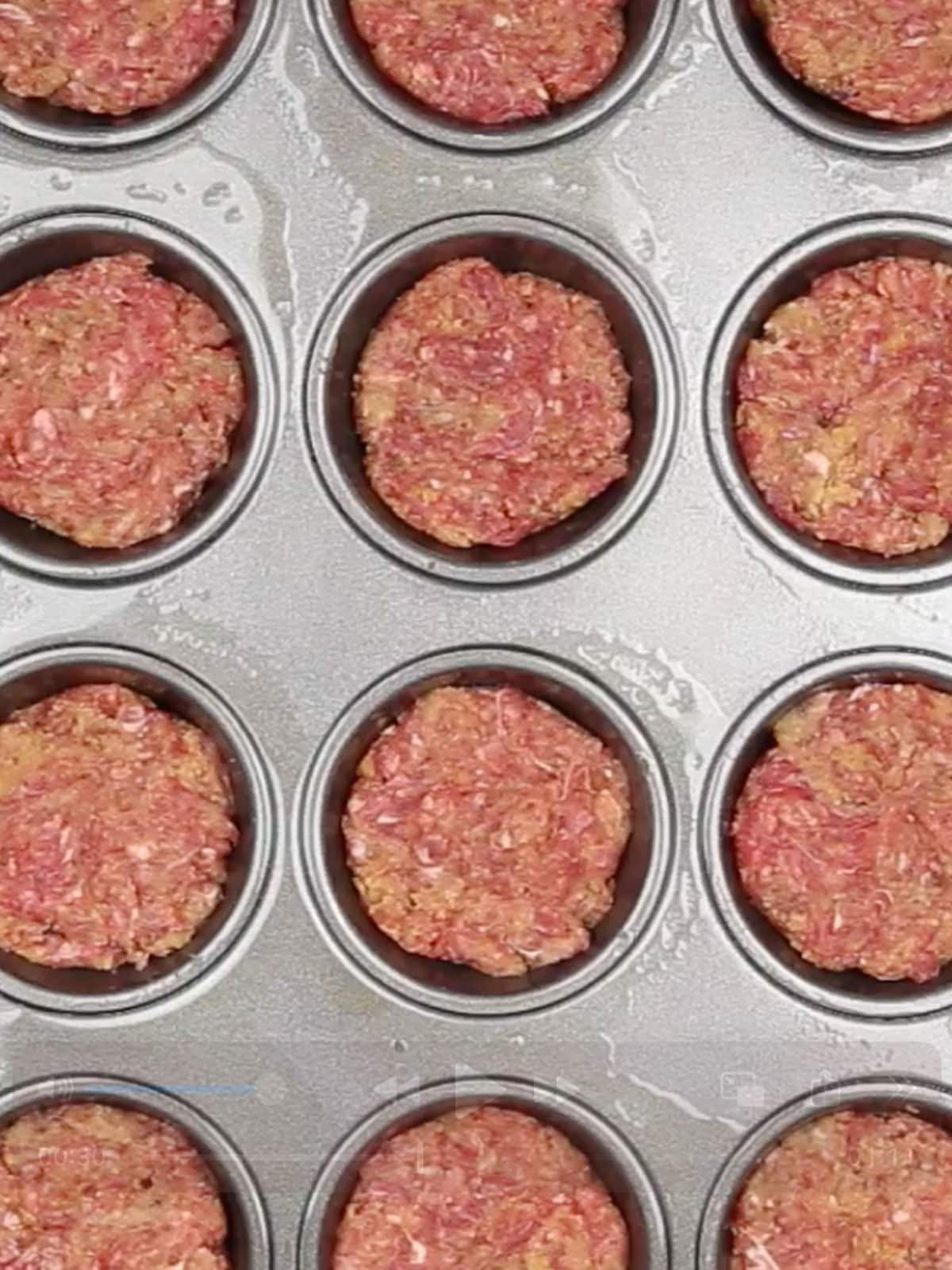 The mini meatloafs in the prepared muffin tin.