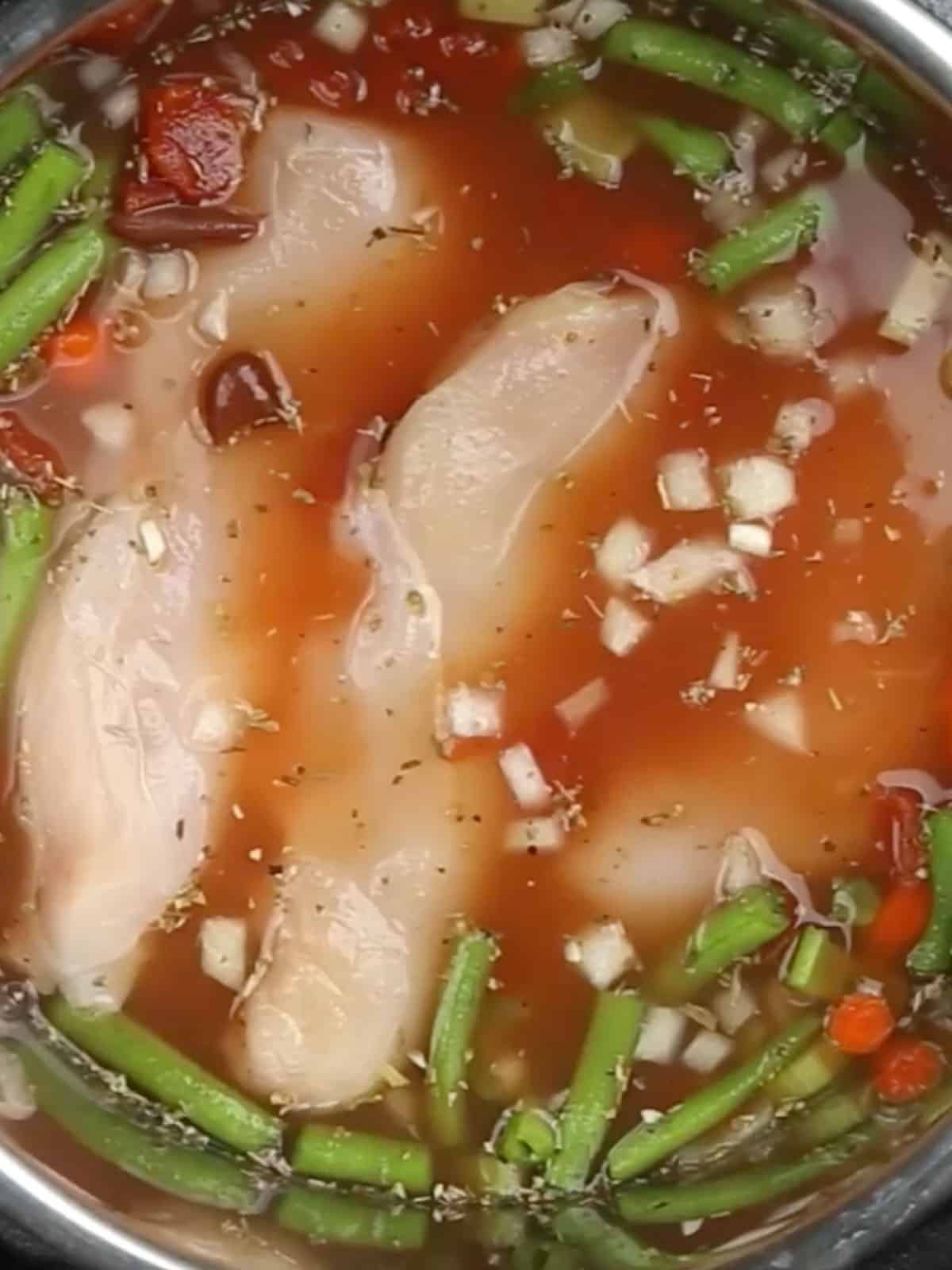 Raw chicken pieces added to the instant pot the the rest of the soup ingredients.