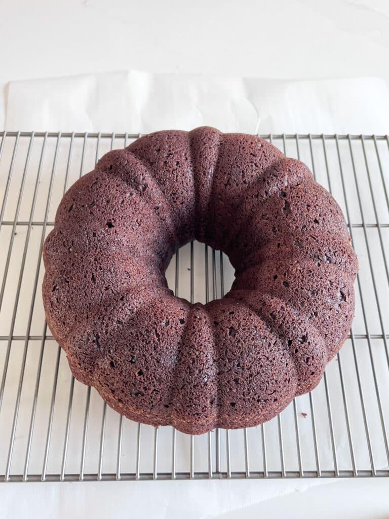 Chocolate bundt cake cooking on a cooling rack.